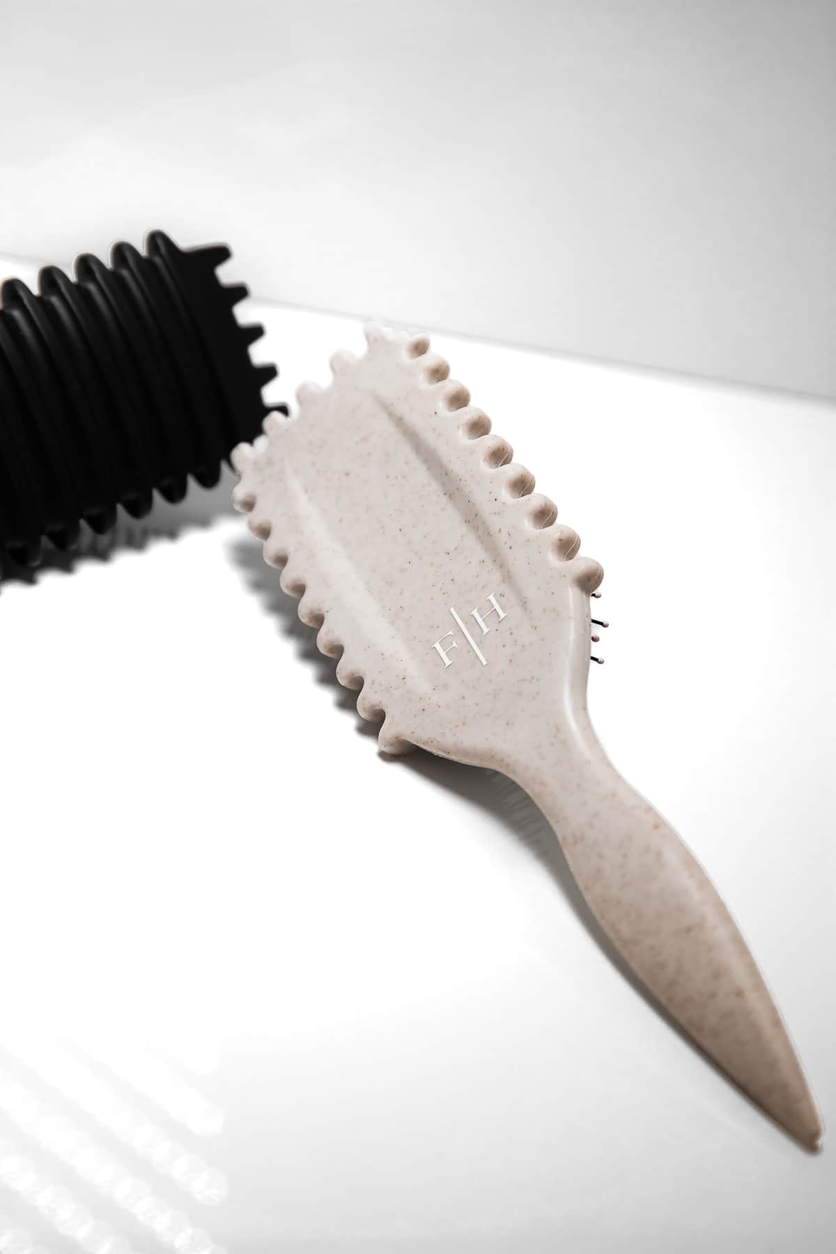 Detaljbild av baksidan på beige och svart Bounce Curl Define Brush – borstar för definierade lockar och krullar