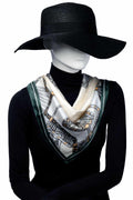 Skyltdock bär Elegant scarf i silkesliknande material i klassisk stil. Designen har gröna kanter och ett mönster i svart, vitt och guld