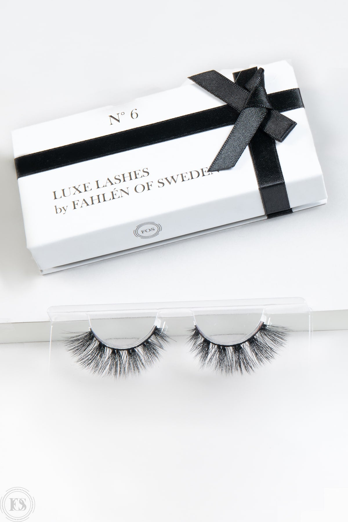 Svartvit produktbild på lösgonfransar med förpackning, perfekt för att visa produktens design och presentation