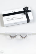 Elegant förpackning med texten “Luxe Lashes by Fahlén of Sweden” och en svart sidenrosett, placerad ovanför ett par fylliga, naturligt formade lösögonfransar i en transparent hållare.